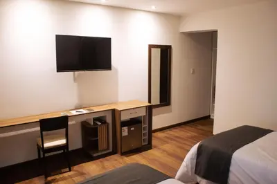 a hotel room with a desk with a television on the wall at Barón de Huaura Hotel Boutique in Huaura