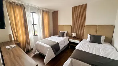 a bedroom with two beds and a window at Barón de Huaura Hotel Boutique in Huaura