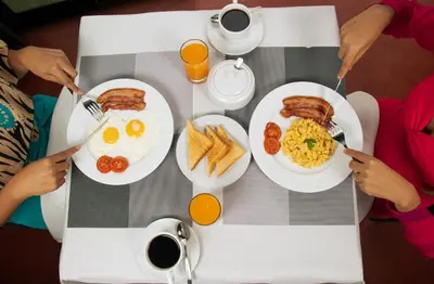 people sitting at a table with eggs and toast at Barón de Huaura Hotel Boutique in Huaura