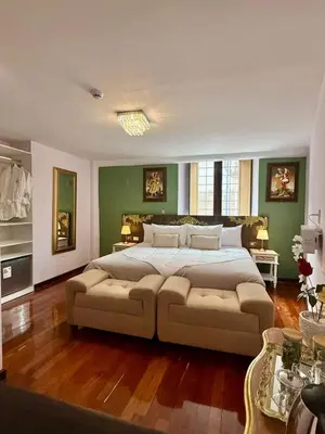 a large bedroom with a large bed and a couch at Ayni Boutique Hotel in Cusco