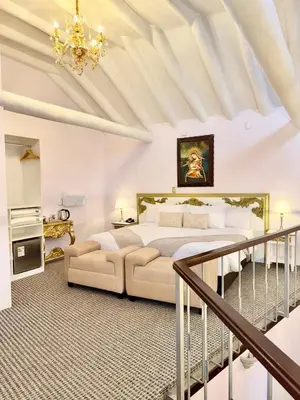 a bedroom with a bed and a chandelier at Ayni Boutique Hotel in Cusco