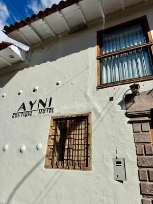 a sign on the side of a building with a window at Ayni Boutique Hotel in Cusco