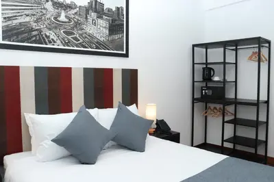a bedroom with a white bed with a picture on the wall at Casa Atempo Boutique Hotel in Lima
