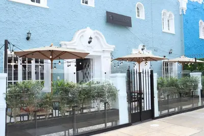 a restaurant with umbrellas in front of a blue building at Casa Atempo Boutique Hotel in Lima