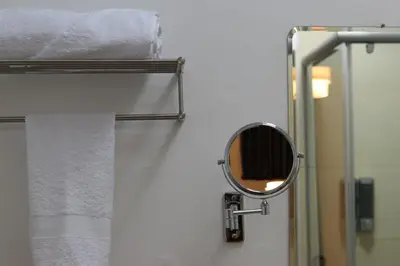 a mirror on the wall of a bathroom with towels at Casa Atempo Boutique Hotel in Lima
