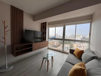 a living room with a couch and a large window at Departamento Salaverry in Lima