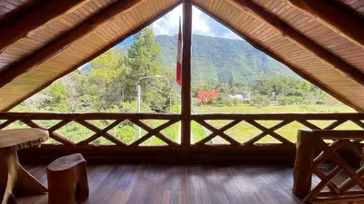 a room with a large window with a view of a mountain at CABAÑAS RANCH OXaPAMP4 in Oxapampa