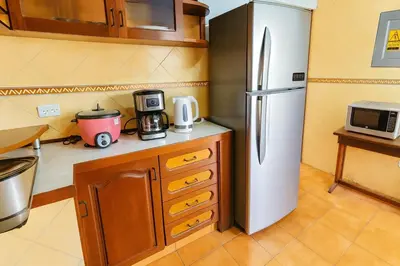 a kitchen with a refrigerator and a microwave at Lima Family Lodge Apartment near Miraflores Center in Lima