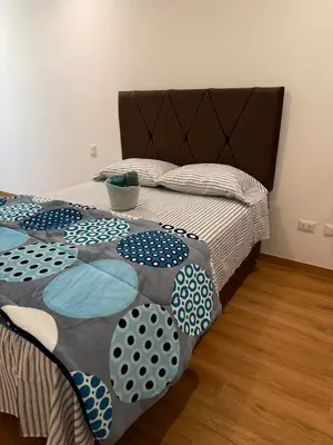 a bedroom with a bed with a comforter on it at TyB apartment in Lima