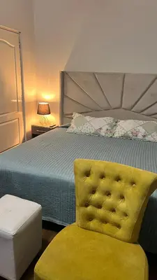 a bedroom with a bed and a yellow chair at Private Whole Apartment in Surco close to Barranco in Lima