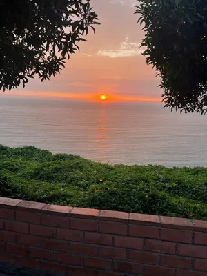 a sunset over the water with a brick wall at Private Whole Apartment in Surco close to Barranco in Lima