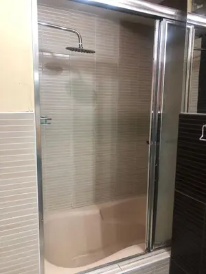 a shower with a glass door in a bathroom at Departamento familiar Lucrepata in Cusco