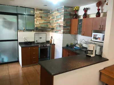 a kitchen with a stove and a counter top at Departamento familiar Lucrepata in Cusco