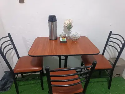 a table with a thermos and flowers on it at IN FRONT OF THE NEW AIRPORT Hospedaje - A y C Taxi Free - Airport - Apartment on the 1st Floor in Lima