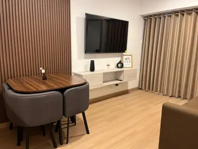 a living room with a wooden table and a television at Apartamento Amoblado a un paso del parque de las aguas in Lima