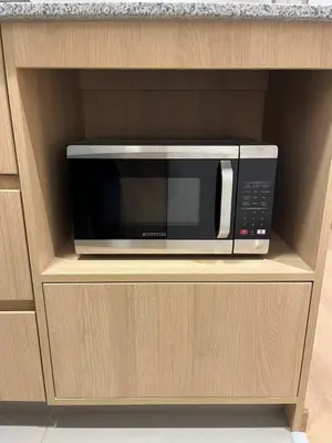 a microwave sitting on a shelf in a cabinet at Apartamento Amoblado a un paso del parque de las aguas in Lima