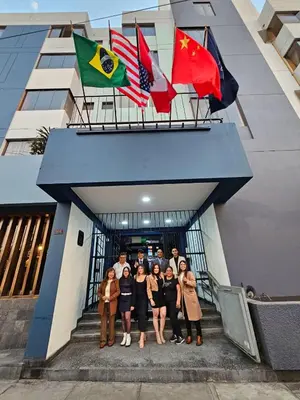 a group of people standing in front of a building with flags at Hotel Naciones Unidas in Lima