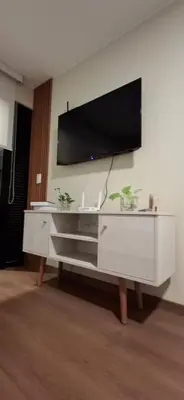 a white entertainment center with a flat screen tv on a wall at Acogedor departamento 1 dormitorio in Lima