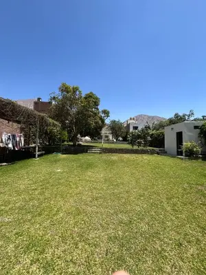 a yard with a large grassy yard with a building at La Casita de Condoray - Lunahuana in Lunahuaná