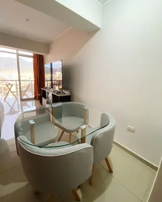 a living room with a glass table and a chair at Apartment in downtown Huancayo in Huancayo