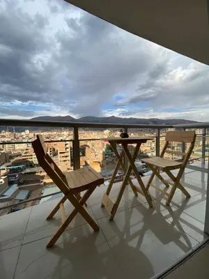 two chairs and a table on a balcony with a view at Apartment in downtown Huancayo in Huancayo