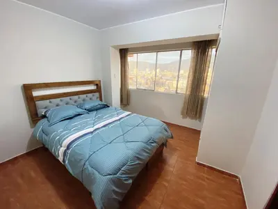 a bedroom with a bed and a large window at Apartment in downtown Huancayo in Huancayo