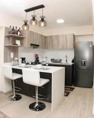 a kitchen with a bar with two stools and a refrigerator at Nice Department Full Equip in Barranco - Gym, Pool in Lima