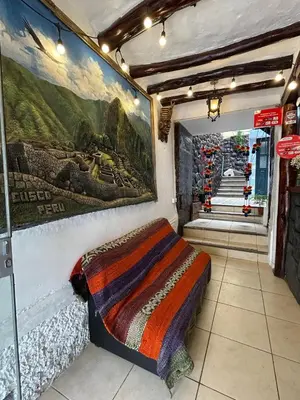 a room with a bed and a wall with paintings at HOTEL PALACE DIAZ inn in Cusco