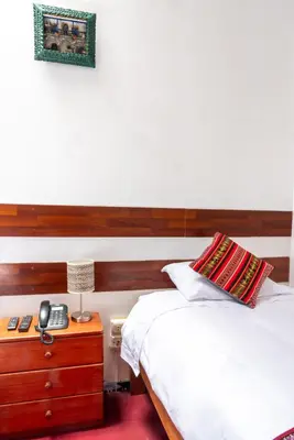 a bedroom with two beds and a night stand with a phone at HOTEL PALACE DIAZ inn in Cusco
