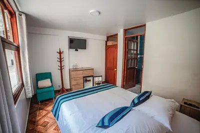 a bedroom with a bed with blue pillows on it at Casa Andora in Machu Picchu