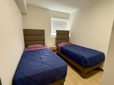 a room with two beds and a window at Departamento Style in Lima