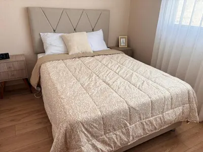 a bedroom with a large bed with a white comforter at Modern apartment with great view in Lima in Lima