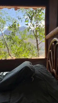 a bed with a pillow in front of a window at Casa Divina Medicina in Urubamba