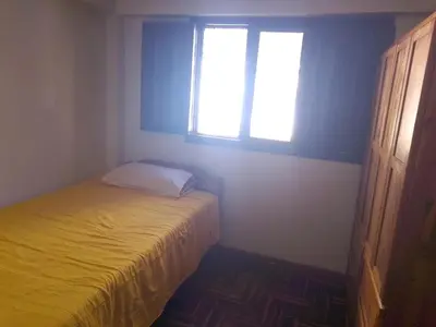 a small bedroom with a bed and two windows at El despertar del inka in Cusco