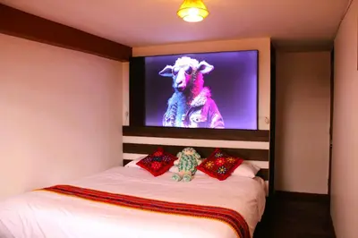 a bedroom with a bed with a tv on the wall at Mirador All Sur Cusco in Cusco