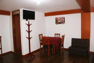a dining room with a table and a tv on the wall at Mirador All Sur Cusco in Cusco