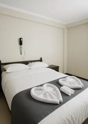 two beds with white towels on top of them at Hotel Naciones Unidas in Lima