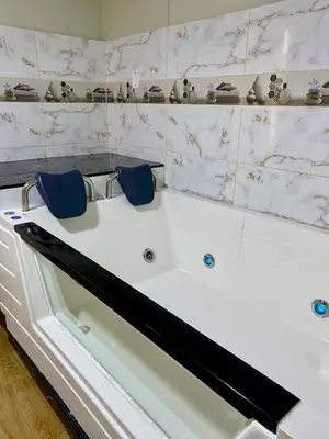 a white bath tub with two blue chairs in it at Hotel Naciones Unidas in Lima