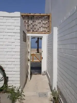 a doorway to a building with a view of the ocean at Departamento con salida a la playa Punta Rocas 202 in Punta Negra