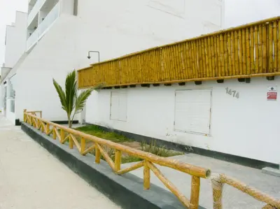 a wooden bench in front of a building at Departamento con salida a la playa Punta Rocas 202 in Punta Negra