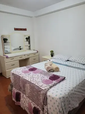 a bedroom with two beds and a vanity and a mirror at Habitación privada cerca del aeropuerto in Lima