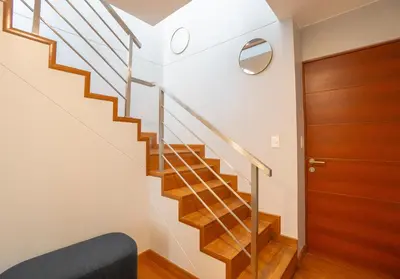 a staircase in a house with a wooden door at Duplex Moderno y Espacioso en Miraflores in Lima
