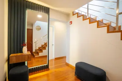 a living room with a staircase and a chair at Duplex Moderno y Espacioso en Miraflores in Lima
