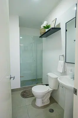 a white bathroom with a toilet and a sink at Duplex Moderno y Espacioso en Miraflores in Lima