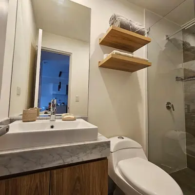 a bathroom with a white sink and a toilet at Modern Brand New Apartment in Miraflores in Lima