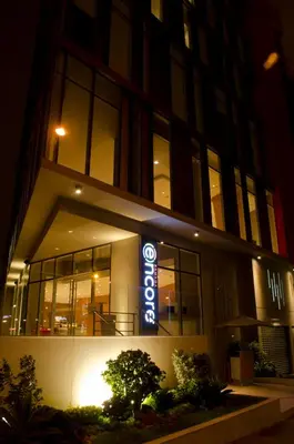 a building with a neon sign in front of it at Ramada Encore by Wyndham Lima San Isidro in Lima