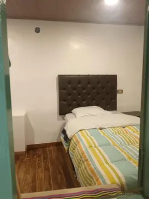 a bedroom with a bed with a brown headboard at Redy's House in Cusco