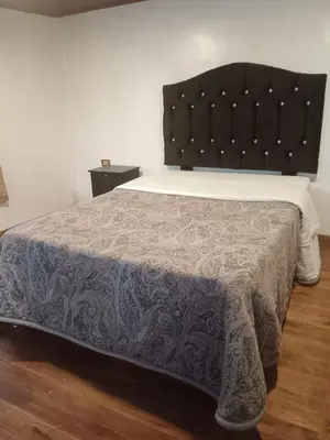 a bedroom with a large bed with a black headboard at Redy's House in Cusco