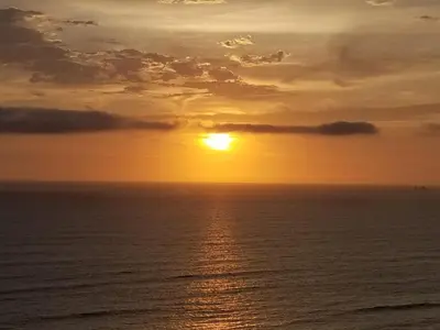 a sunset over the ocean with the sun in the sky at Miraflores Cozy Private Apartment with ocean view in Lima