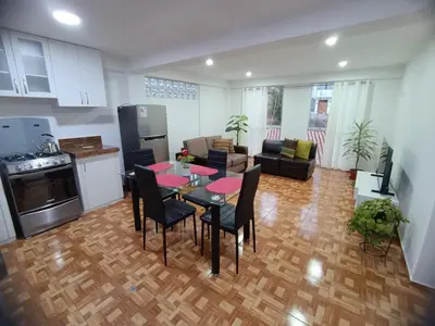 a kitchen and a living room with a table and chairs at Apartamento en Cusco IV in Cusco